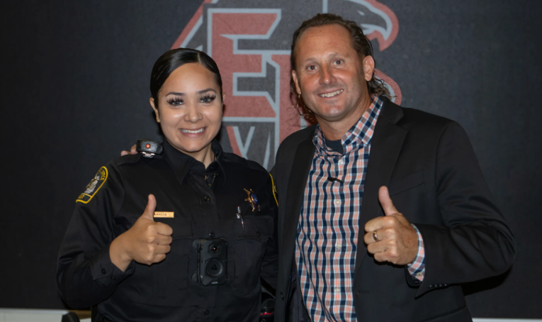 Karen Barrose, in her police uniform, poses with man at East Kentwood High School